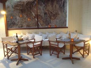 een eetkamer met 2 tafels en een bank bij Mandaniki Apartments in Vassilias