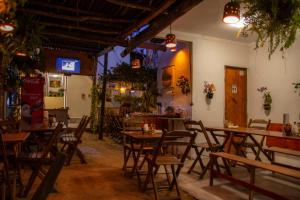 um restaurante com mesas e cadeiras de madeira numa sala em Pousada Villa Flores em Jericoacoara