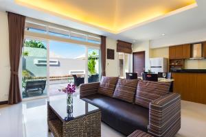 a living room with a couch and a kitchen at Villa Jasmine in Rawai Beach