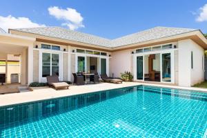 a swimming pool in front of a house at Villa Jasmine in Rawai Beach