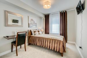 a bedroom with a bed and a desk and a window at Henia's INN in Ottawa