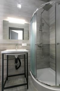 a bathroom with a glass shower and a sink at Motel Sun Lit in Ivano-Frankivsʼk