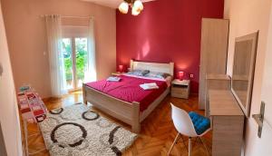 1 dormitorio rojo con 1 cama y 1 silla en Apartments Jovana, en Kotor