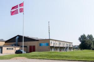 un bâtiment doté d'un drapeau devant lui dans l'établissement Pulzion - Sportshotel, à Kolding