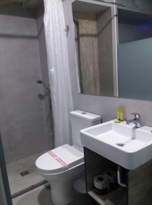 Un baño con inodoro, lavabo y ducha. en athens.apartotel.box, en Atenas