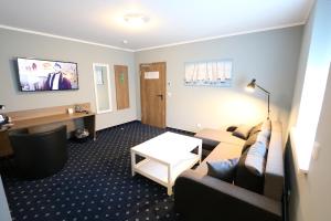 a living room with a couch and a table at Hotel Deutscher Hof in Babenhausen