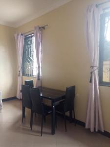 a dining room with a table and chairs and a window at Jfour comfort zone hostel in Dar es Salaam
