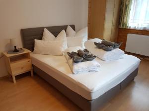 a bed with white sheets and pillows on it at Ferienwohnung Dominik in Neustift im Stubaital