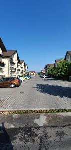 a street with cars parked in a parking lot at Apartament Comfort Primaverii in Râşnov