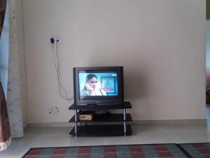 a television sitting on a stand in a room at Seri Baqti Homestay in Tanah Merah