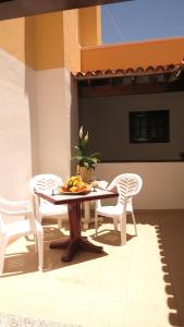 een tafel en stoelen met een fruitschaal erop bij Large apartment on golf course in San Miguel de Abona