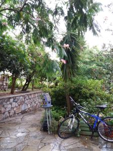 ein Fahrrad, das neben einer Steinmauer mit einem Vogelhaus parkt in der Unterkunft Anofli Suites in Skopelos