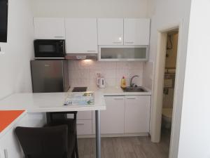 a small kitchen with white cabinets and a table at Apartment Vinko in Split
