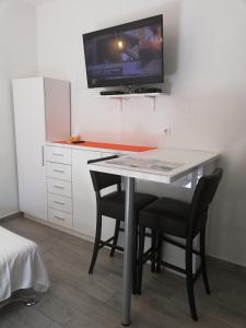 a desk with two chairs and a tv on a wall at Apartment Vinko in Split