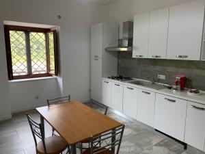 Pratella的住宿－Vista sul Lete，厨房配有白色橱柜和木桌