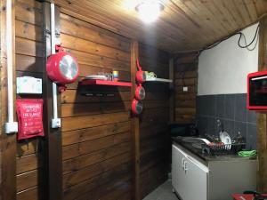 a kitchen with a wooden wall with pots and pans at Chambre1 Résidence Beauregard in Koungou