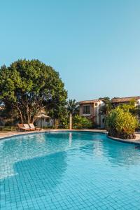 ein großer blauer Pool mit Bäumen im Hintergrund in der Unterkunft Hotel Varandas Mar De Pipa in Pipa