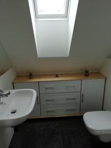 W łazience znajduje się umywalka, lustro i toaleta. w obiekcie Apartman Aisha w Wielkiej Łomnicy