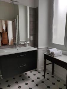a bathroom with a sink and a mirror and a table at Suite Hôtel de Ville - Cathédrale in Clermont-Ferrand +18 photos