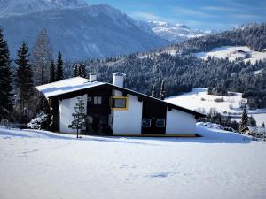 a small house in the snow in the mountains at Schans Appartements in Hermagor