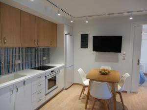 a kitchen with white cabinets and a table and chairs at Cielo mini suita in Karteros