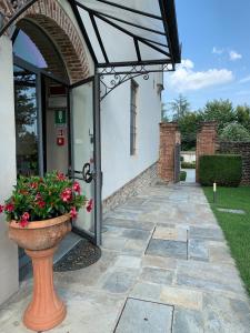 - l'entrée d'un bâtiment avec un vase fleuri dans l'établissement Castello La Rocchetta, à Sandigliano