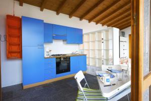 a kitchen with blue cabinets and a table at Casa Bella Terrazza in Ghiffa