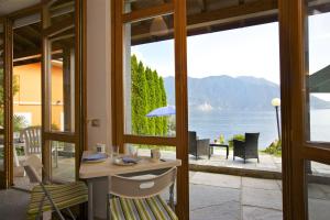 a dining room with a table and a view of the water at Casa Bella Terrazza in Ghiffa