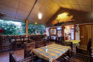 a dining room with tables and chairs in a restaurant at Ninh Binh Palm Homestay in Ninh Binh