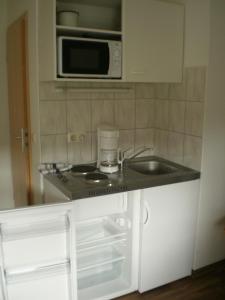 a kitchen with a sink and a microwave at Herzberg in Kleve