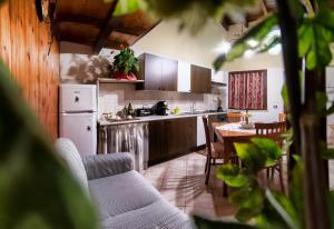 eine Küche mit einem Tisch und einem weißen Kühlschrank in der Unterkunft Casa Serena in Serdiana