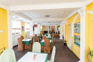 a restaurant with tables and chairs and yellow walls at Hotel Dominus in Bijelo Polje