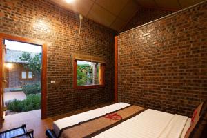 a room with a brick wall with a bed in it at Ninh Binh Palm Homestay in Ninh Binh