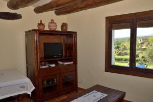 een woonkamer met een tv en een raam bij Apartamento Vivienda Sampietro in Radiquero