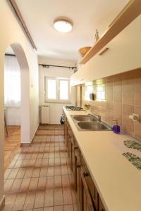 eine Küche mit einer Spüle und Fliesenboden in der Unterkunft Apartman Zen in Zagreb