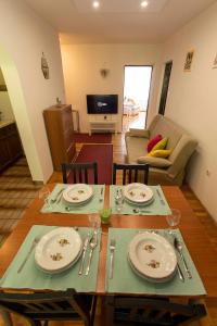 ein Wohnzimmer mit einem Tisch mit Tellern und Gläsern in der Unterkunft Apartman Zen in Zagreb