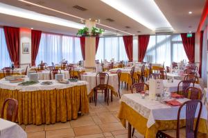 a banquet hall with white tables and chairs at Hotel Tiglio in Rimini