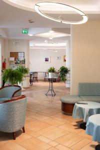 a waiting room with chairs and tables in a building at Hotel Tiglio in Rimini