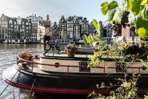 un bateau dans l'eau avec des plantes en pot dessus dans l'établissement Hotel Amstelzicht, à Amsterdam