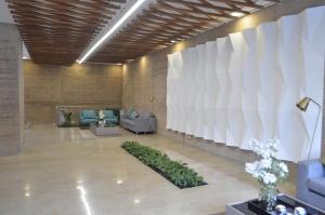 a lobby with a large white wall with a plant at Loft Cool Equilibrium in Bogotá +42 photos