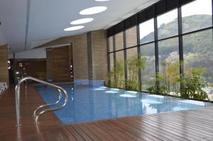a large swimming pool in a building with windows at Loft Cool in Equilibrium in Bogotá