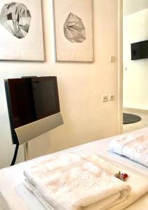 a bedroom with a television and a bed with a blanket at Apartments@Tsiantas in Kavála