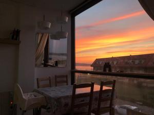 - une salle à manger avec une table et une vue sur le coucher du soleil dans l'établissement Somo Playa Vistas, à Somo