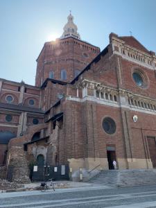 パヴィアにあるLa finestra sul Duomo di Paviaの時計塔のある大きなレンガ造りの建物