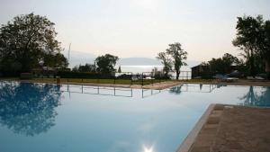 a large swimming pool with a view of the water at Fornella Camping & Wellness family resort in San Felice del Benaco