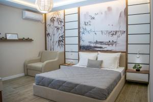 um quarto com uma cama grande e uma cadeira em Apartments Stanaj em Ulcinj