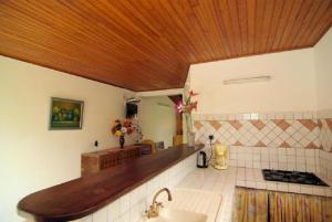a kitchen with a sink and a wooden ceiling at chez Manu in Le Robert