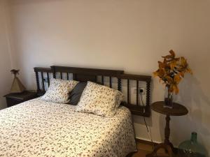 una camera con letto, 2 cuscini e tavolo di Apartamento con terraza y chimenea a La Rebollada