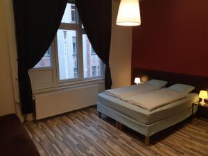 Liechtenstein Apartments في بودابست: غرفة نوم بسرير ونافذة كبيرة