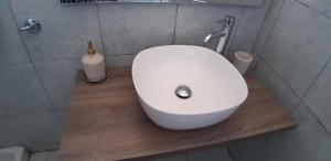 a bathroom with a white sink on a wooden counter at Pericles Traditional Cretan Home in Stavrokhórion